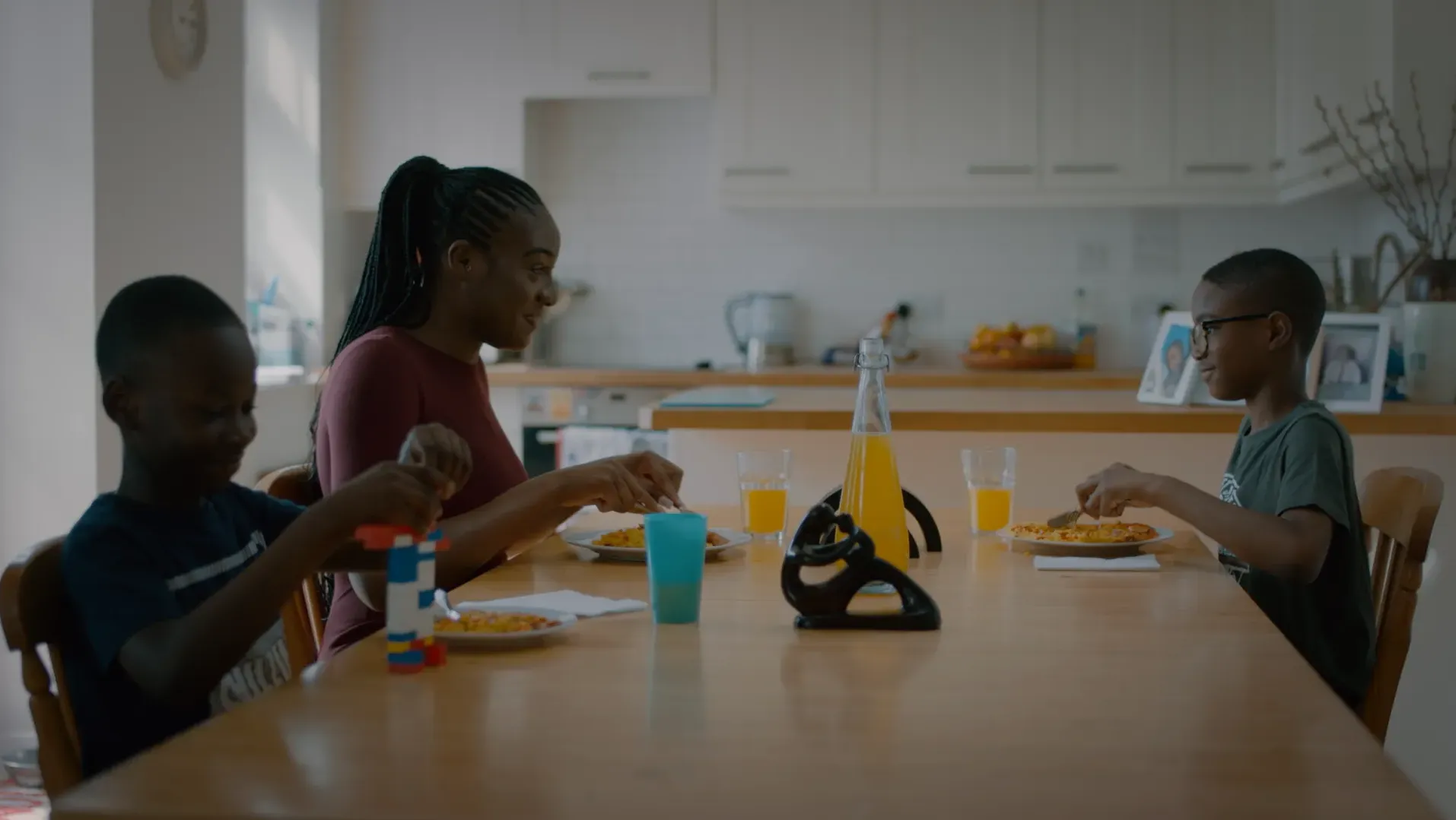 A mother and her two sons eating lunch at the dinning table