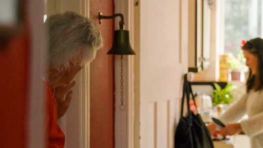 Mum looking at her daughter who is cooking for her