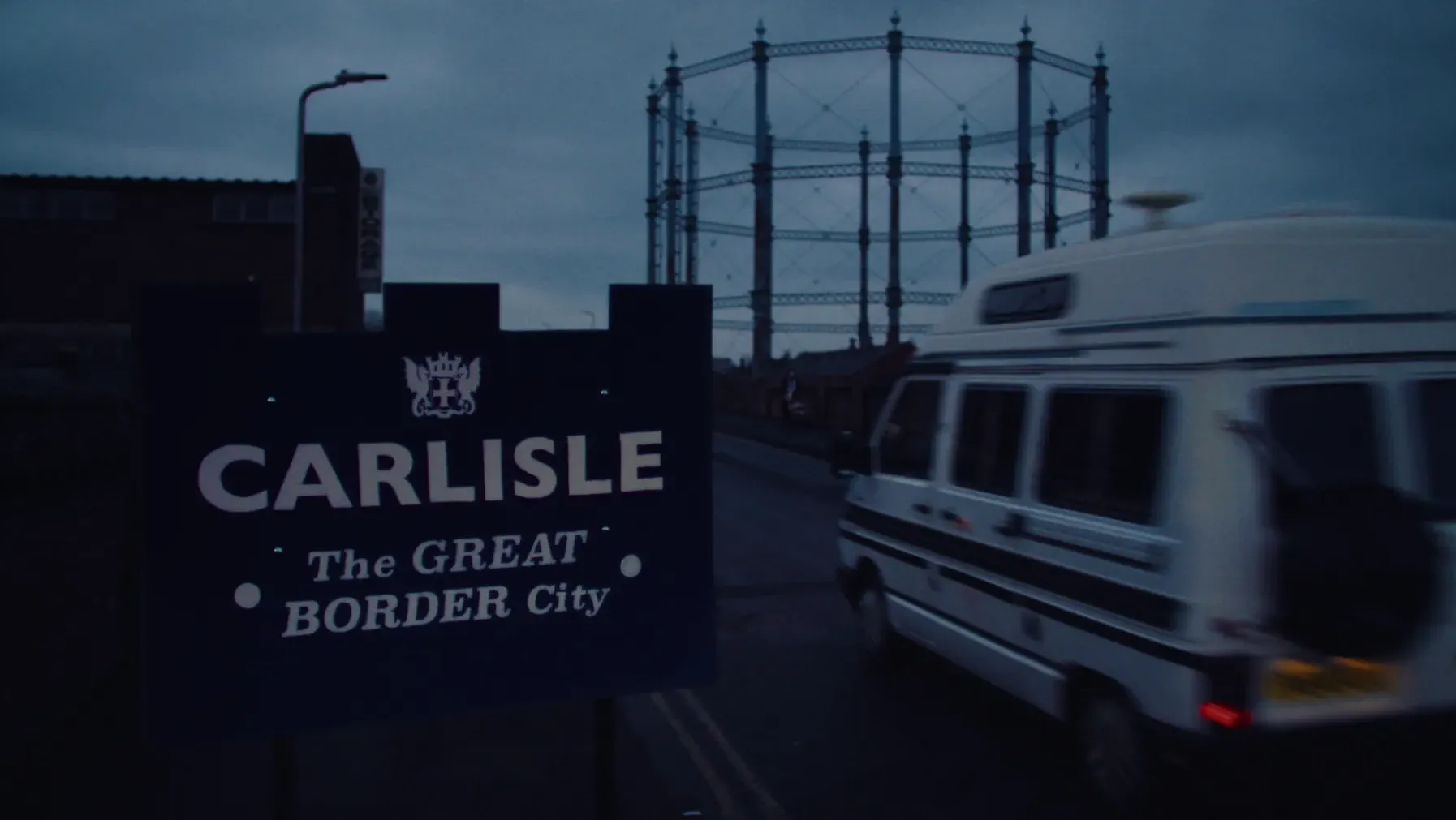 A campervan passed a 'Carlisle' road sign.