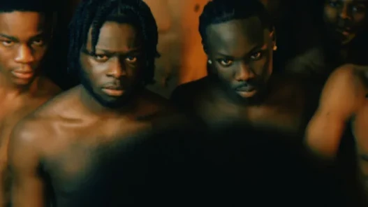 A group of young topless men look forward, striking fear.