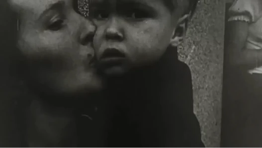 A French woman kisses her son before he is evacuated on a bus out of war-torn Paris during World War 2.