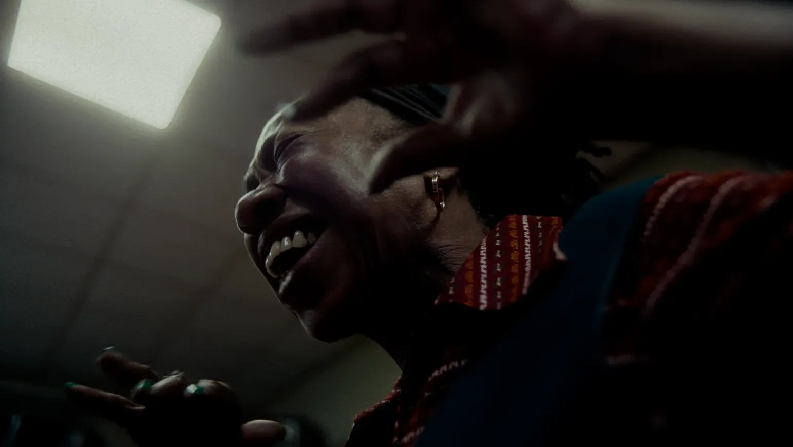 A Black woman sings and dances in a Greater Manchester community centre