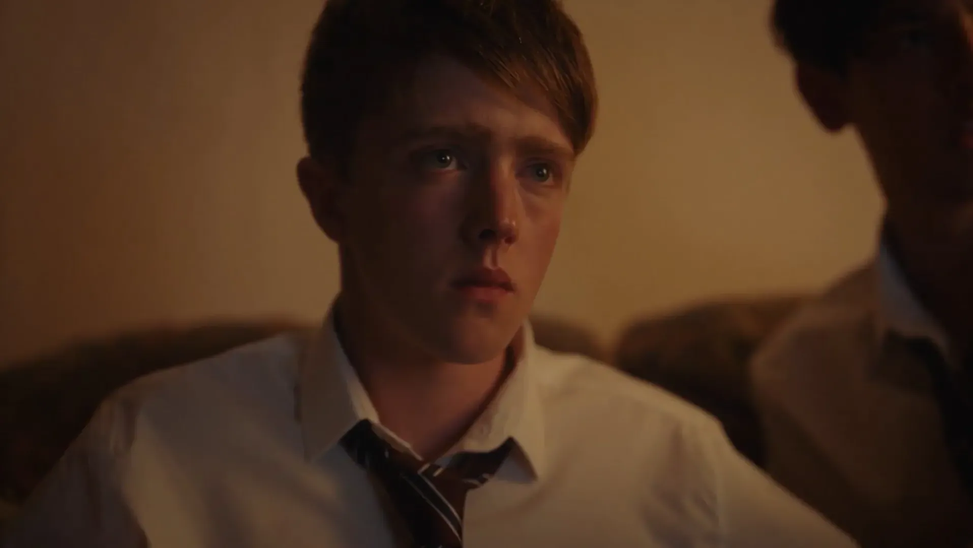 A young man looks intently at something off screen.