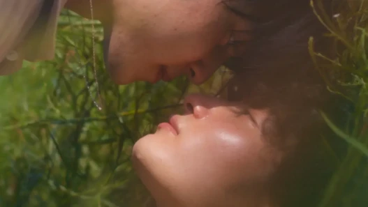 Two young men lay in the grass together