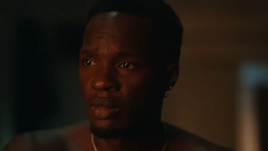 Close up of concerned man in a bedroom, looking off into the distance.