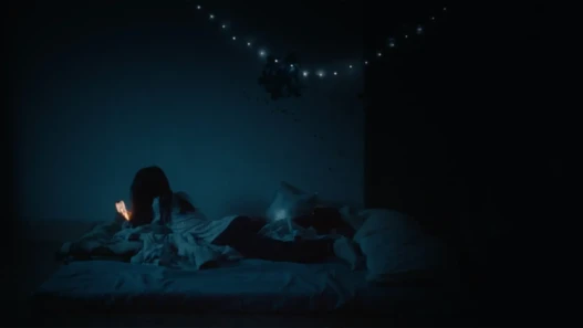 A girl looking at her phone screen in a dark room