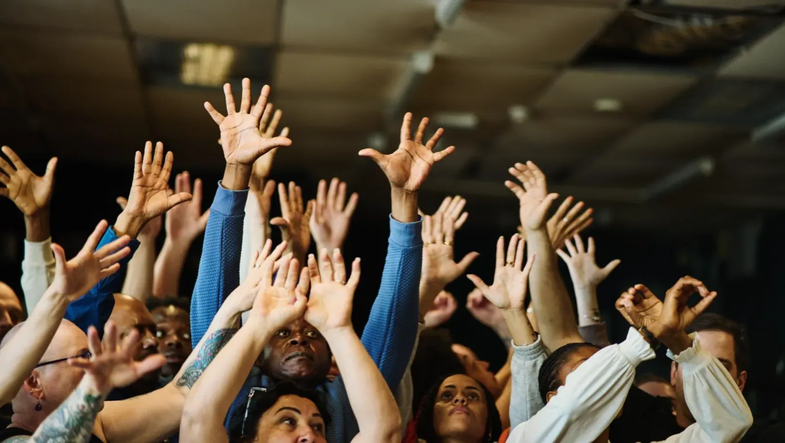 A group of people raise their hands