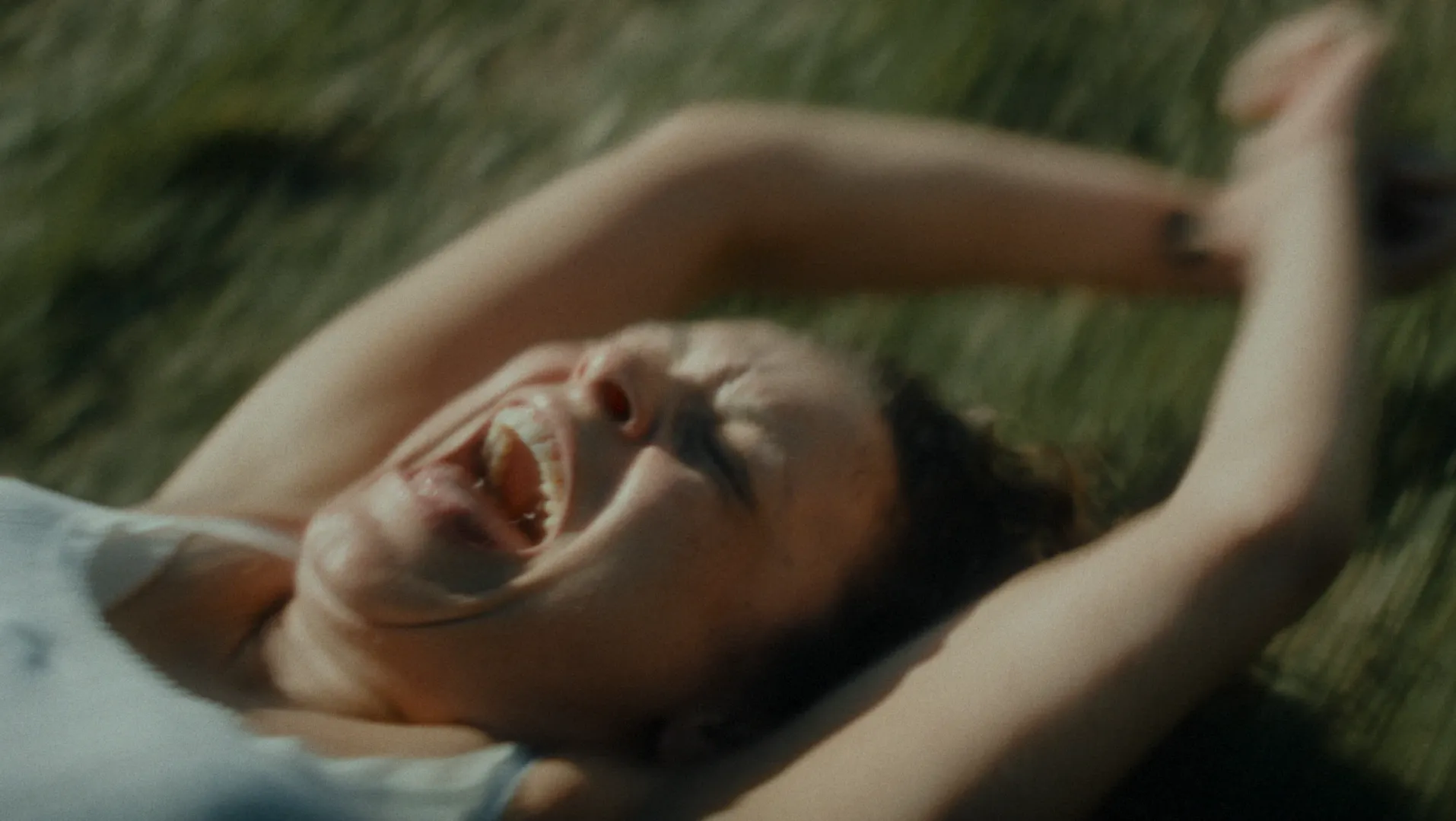 A woman being dragged by her wrists along the ground at high speed