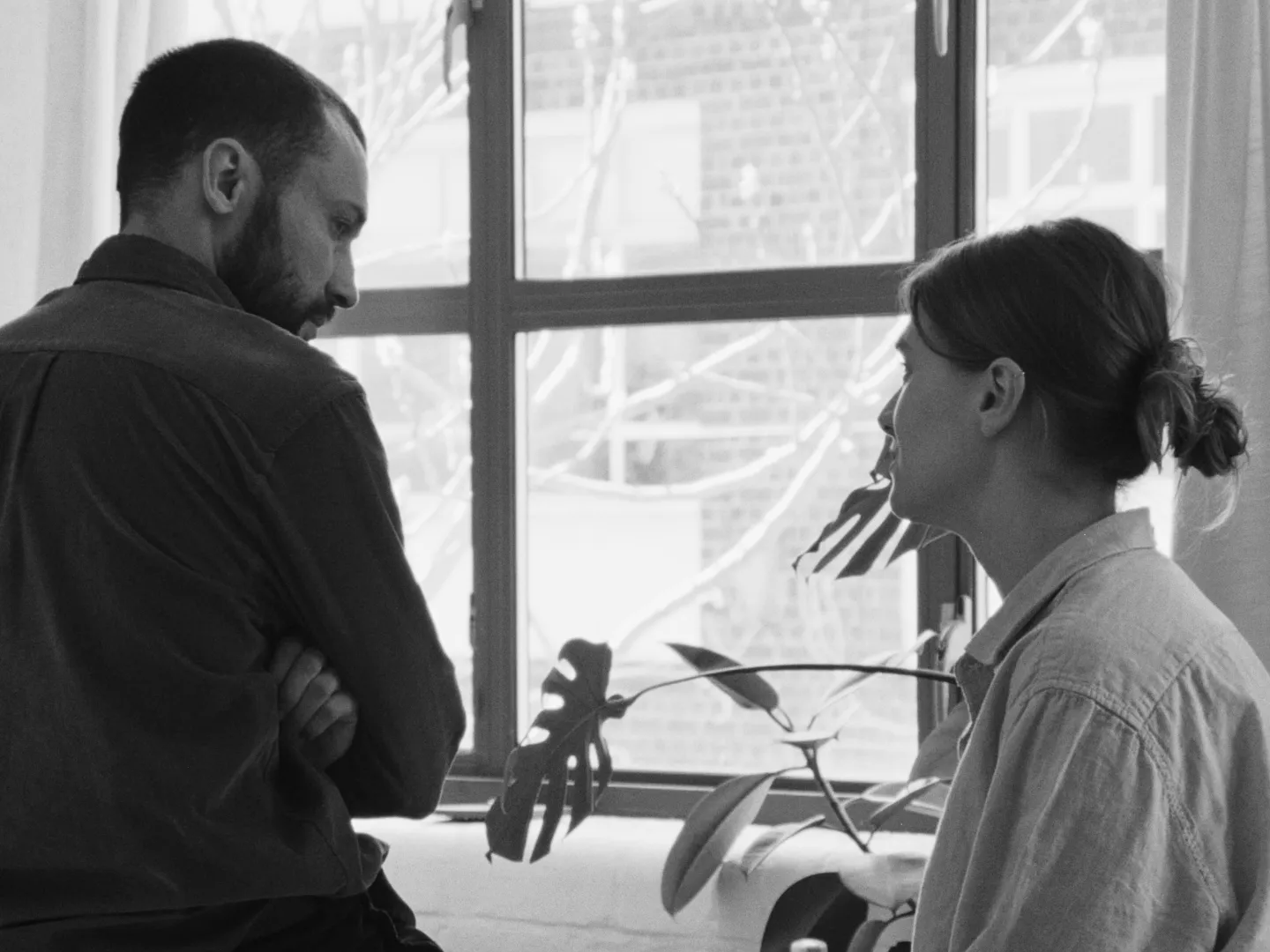 A black and white image of two people arguing.