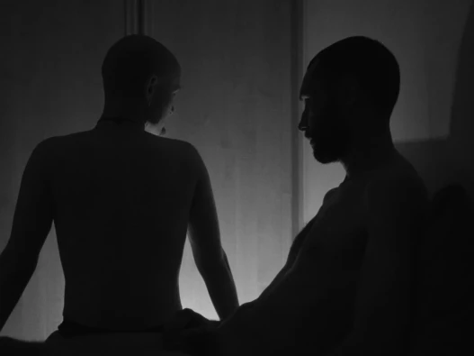 A black and white image of two naked people silhouetted.