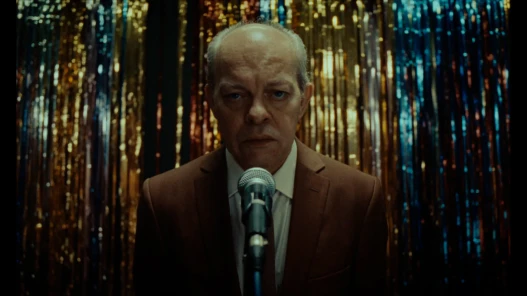 A man stands in front of a microphone