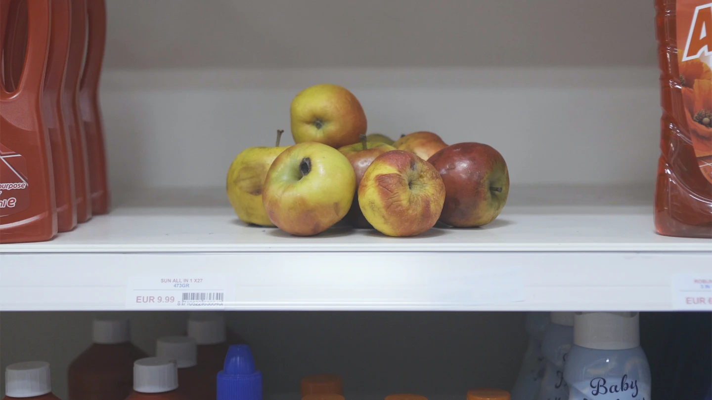 Browning, rotting apples on a supermarket shelf