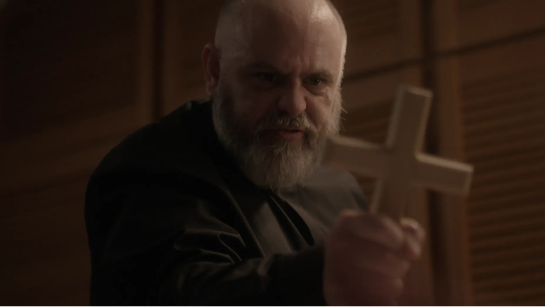 A priest holds a cross.