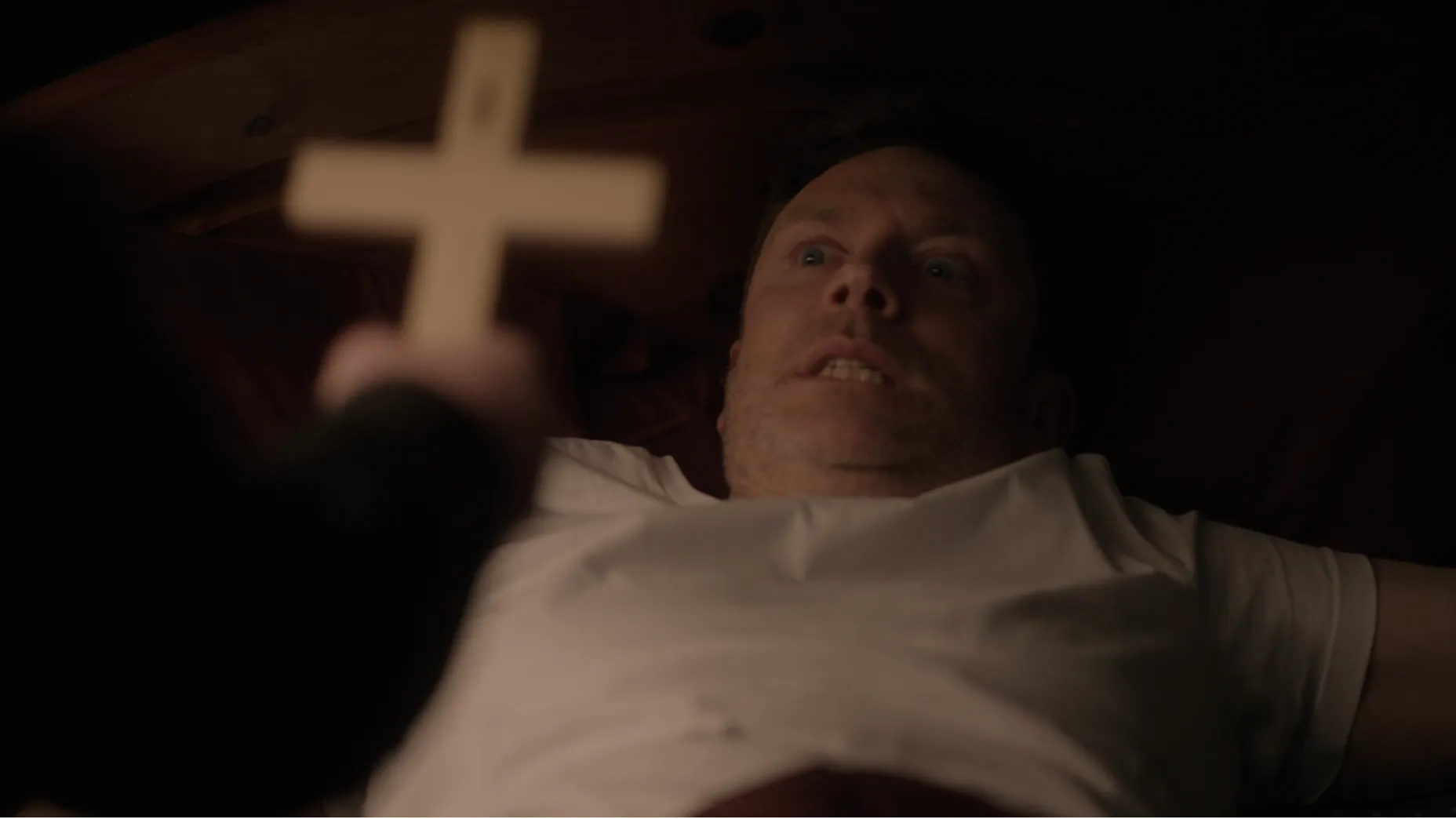 A priest holds a cross.