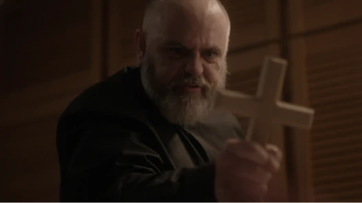 A priest holds a cross.