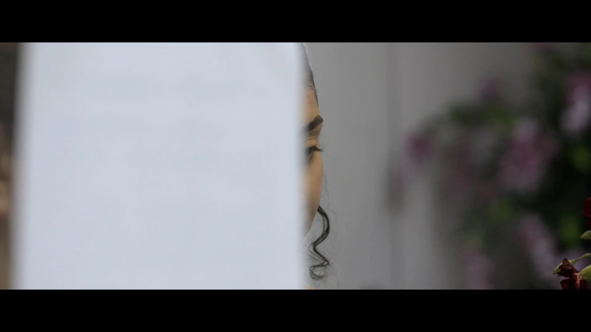 A woman at a counter half hidden by a sheet