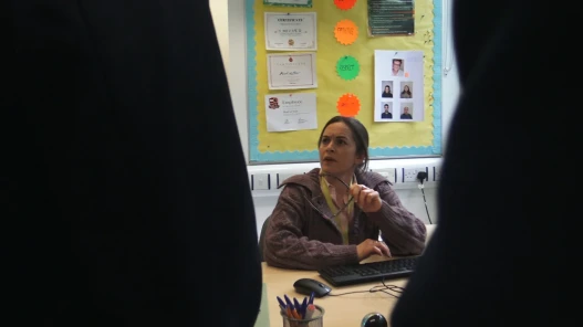 A teacher is confronted by pupils in her office.