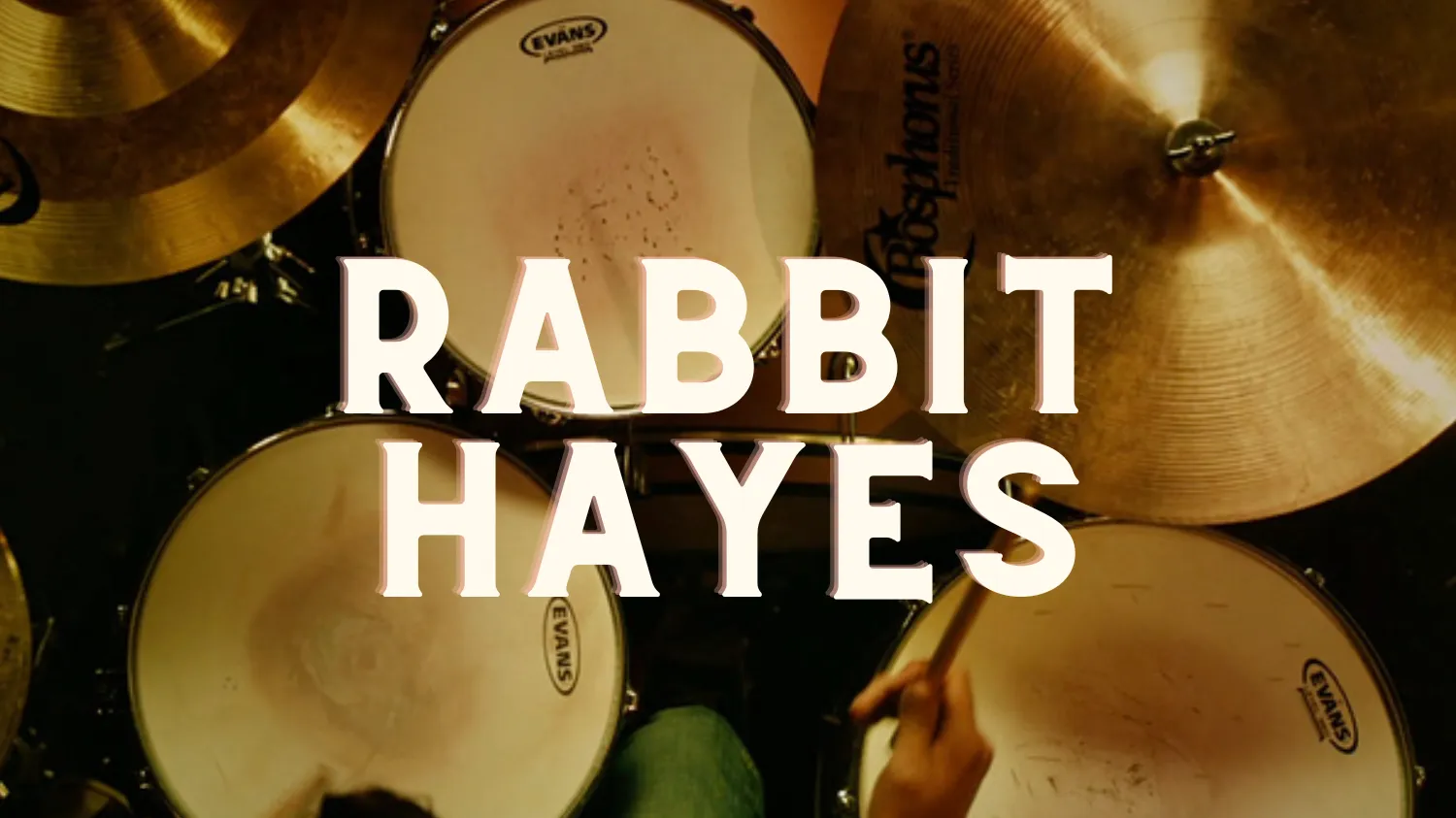 Title card of the film Rabbit Hayes appears over a drum kit.