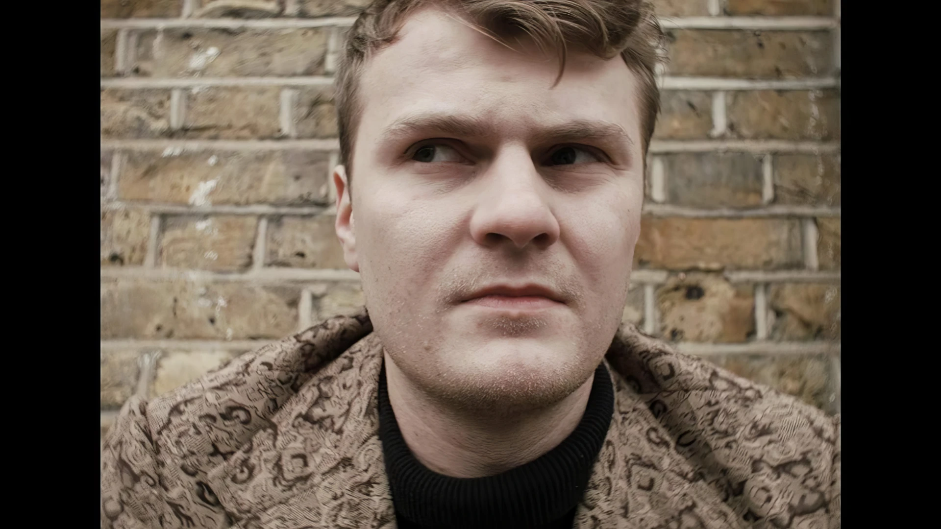 A young man looks concerned at something off camera