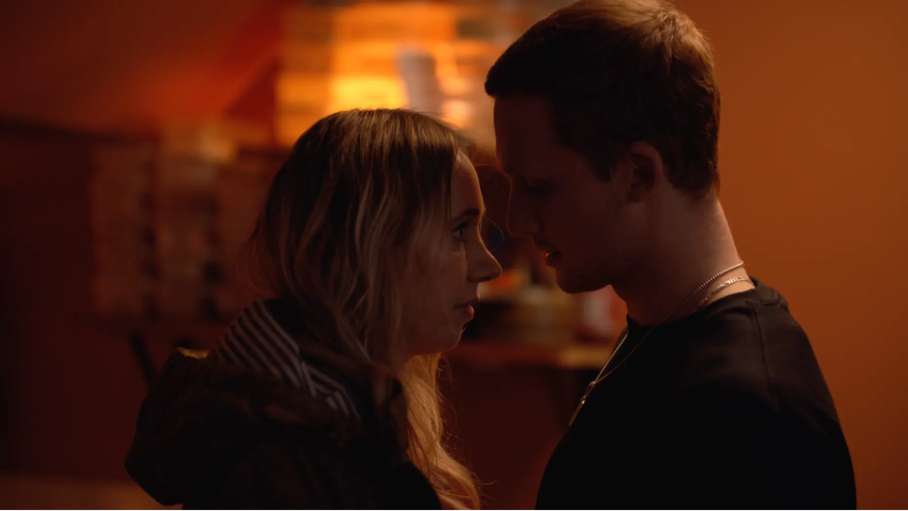 A man and woman standing close together as if about to kiss.