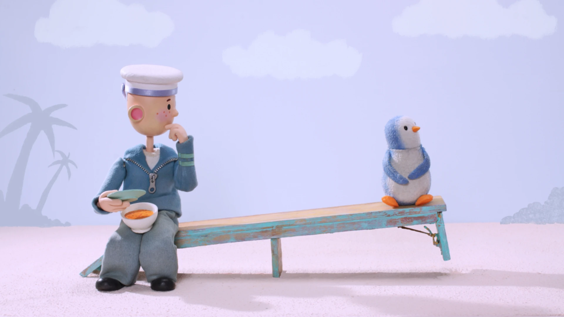 A sailor and a penguin sit on a wooden bench.