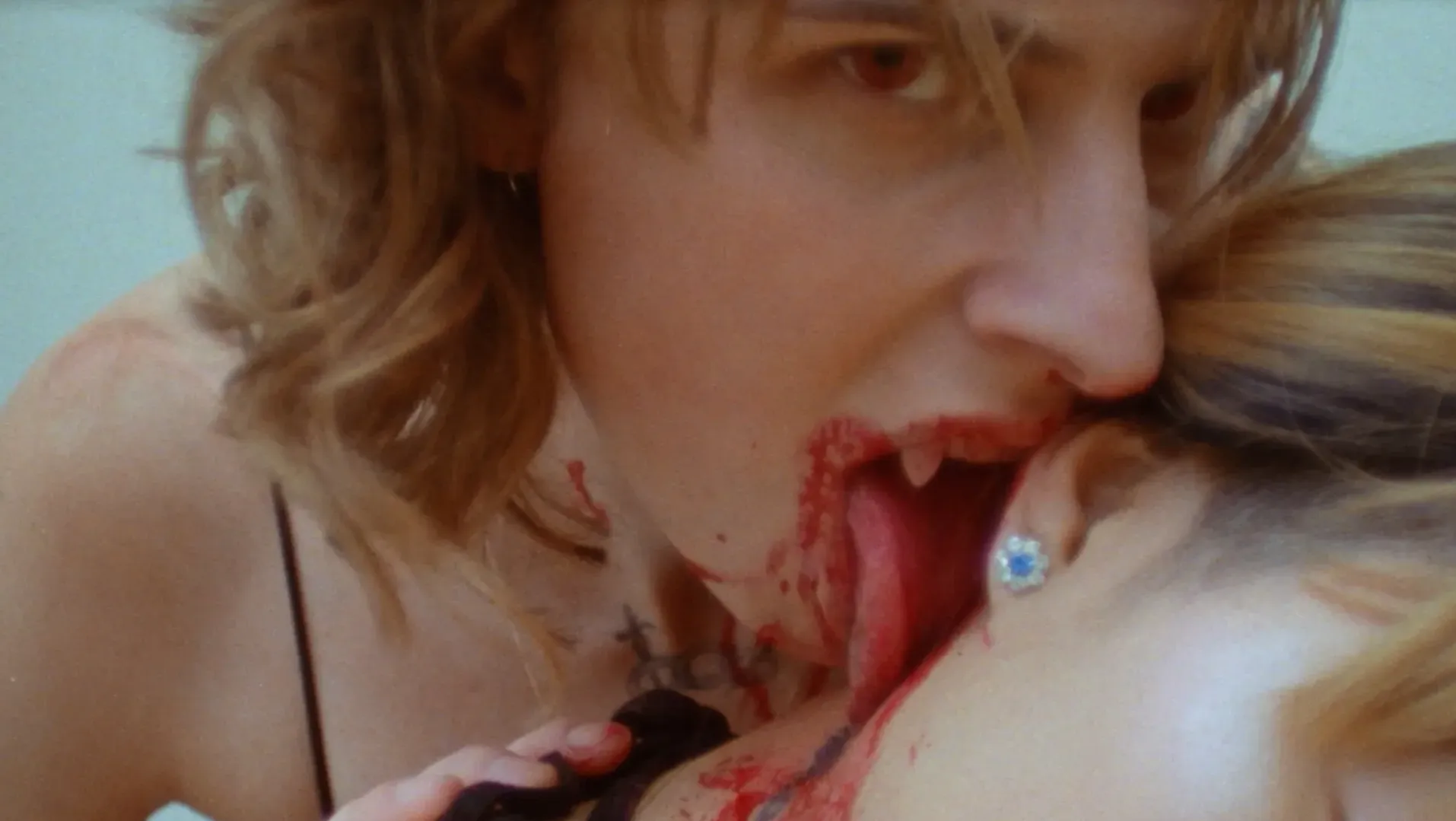 Ailo (Ailo Ribas) licks blood from Tribeca's (Gabi Dao) neck whilst gazing towards the viewer in RESURRECT ME AS A PARASITE