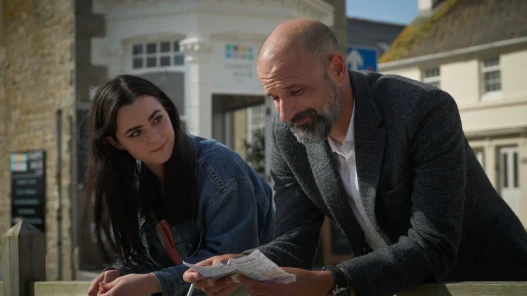 Sinead playing Delilah stands with Tim playing Jack outside a coffee shop on a summers day