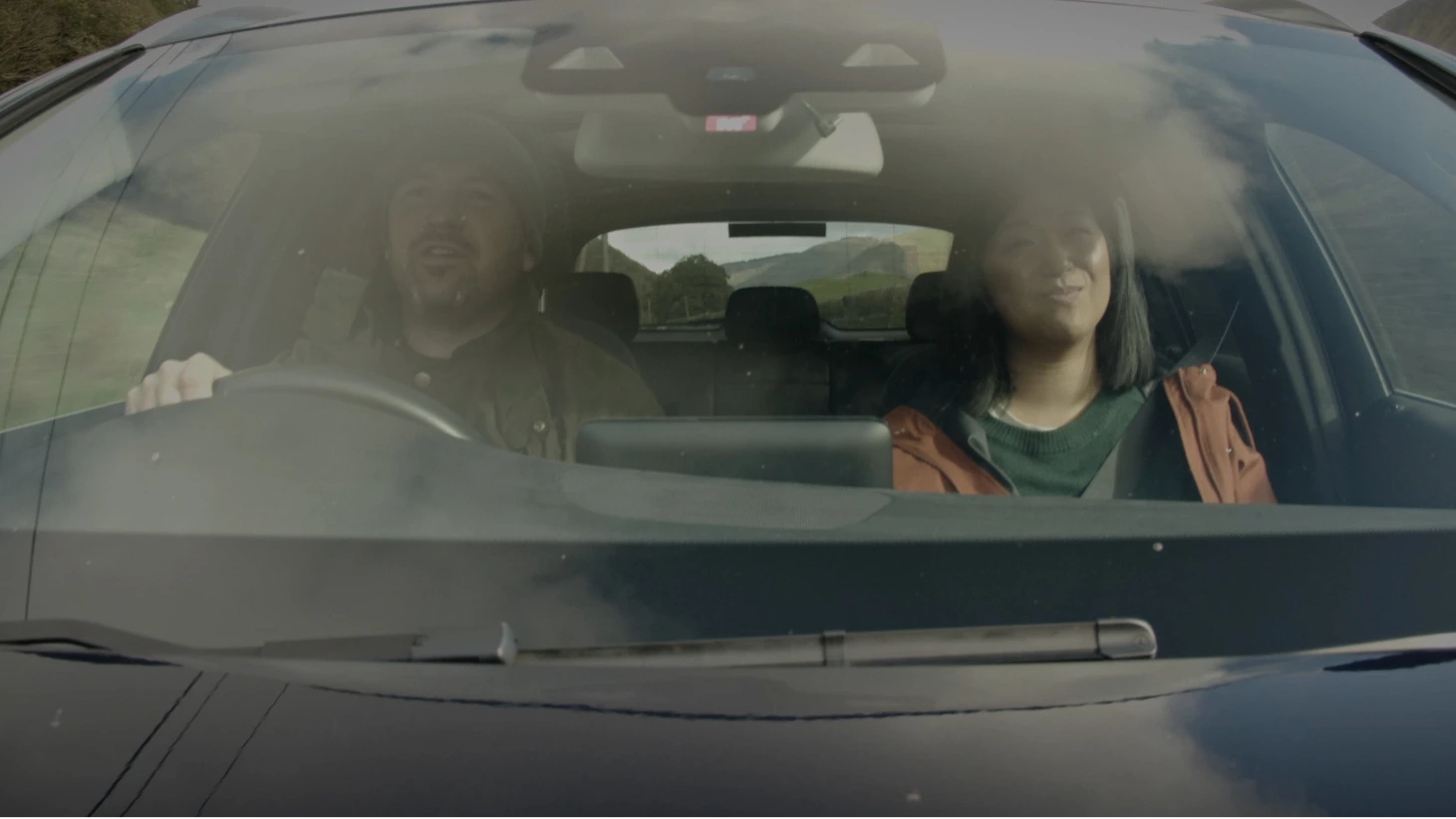 A couple in car driving through countryside