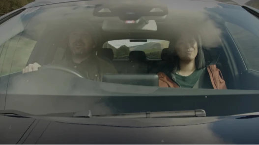 A couple in car driving through countryside