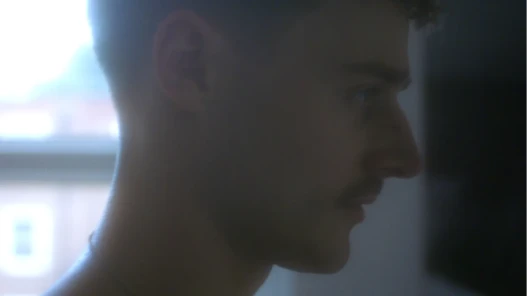 A man's face in profile stood in front of a window.