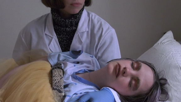 A woman in white lab coat holds another woman