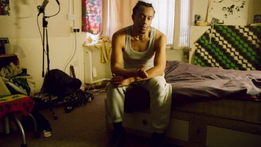 A young man sitting in his room smoking weed