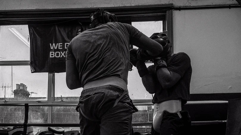 Black and white image. A boxer sparring at a boxing club.