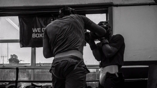 Black and white image. A boxer sparring at a boxing club.