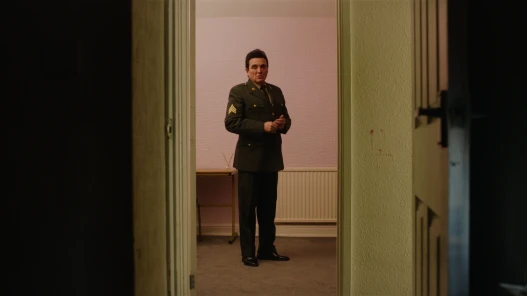 An image of a man stood in an American army uniform stood in a door way.