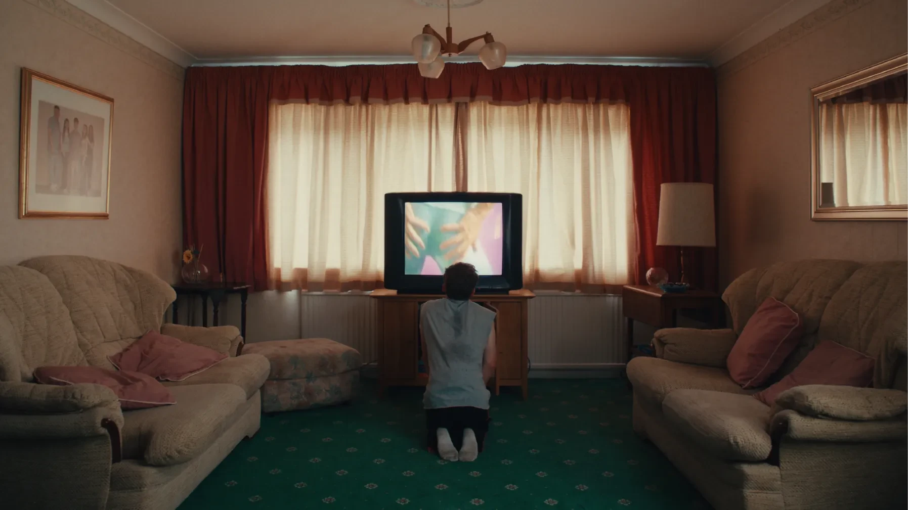 A teenage boy watches a workout video