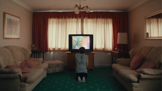 A teenage boy watches a workout video