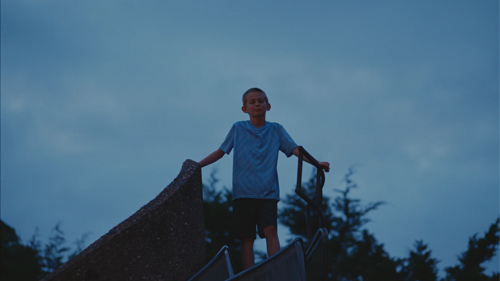A boy stood atop of a playground kingdom