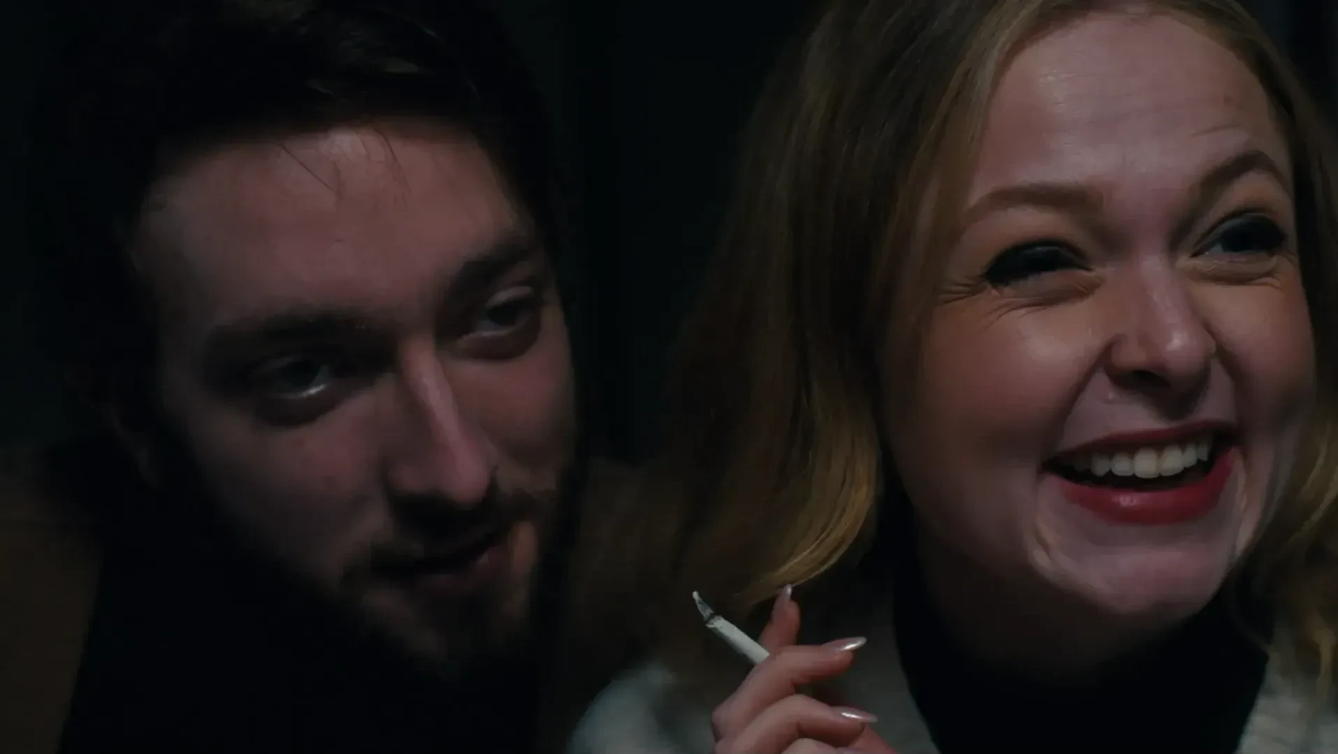 A man and a woman. The woman holds a cigarette.