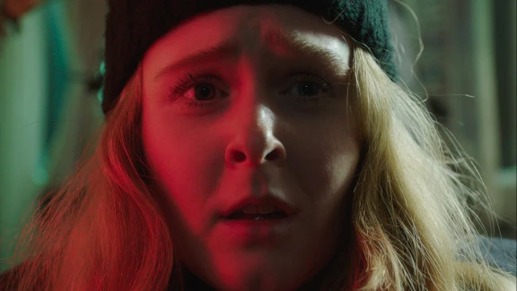 A woman with red lighting on her face