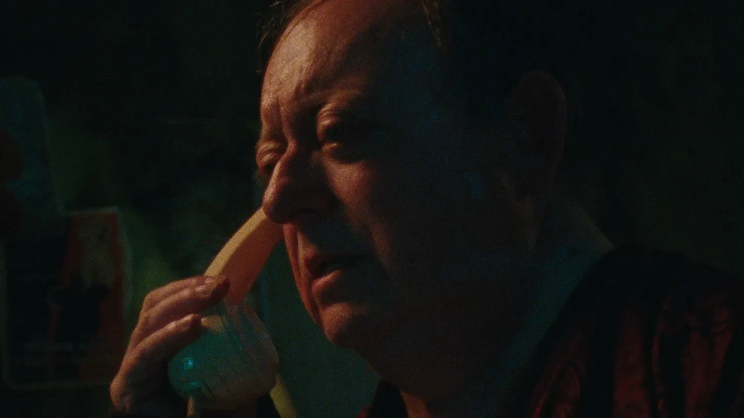 A middle-aged man holds a phone to his ear