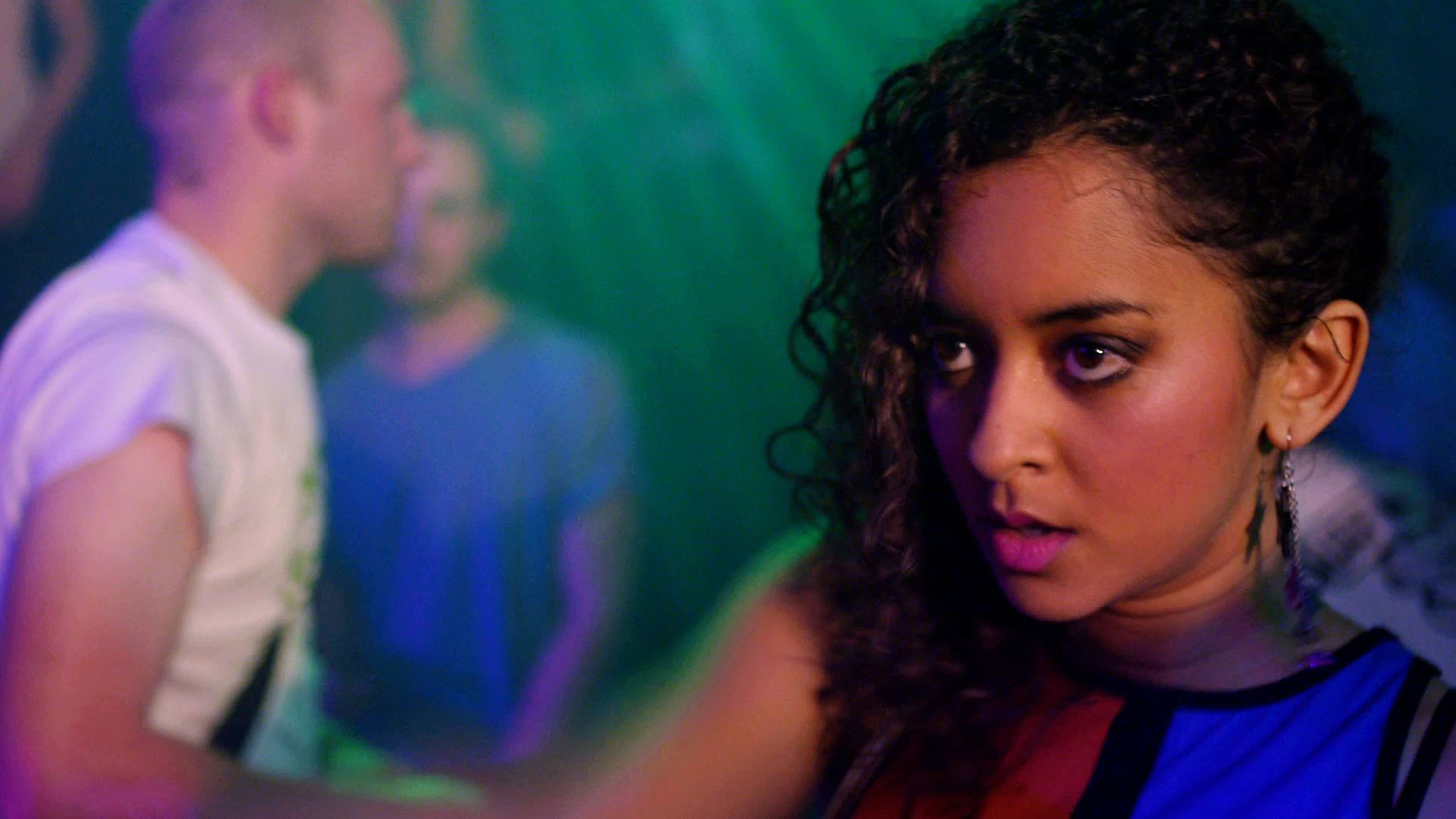Mia, a teenage girl played by Melissa Latouche, is shown inside a nightclub environment with strobe lighting.