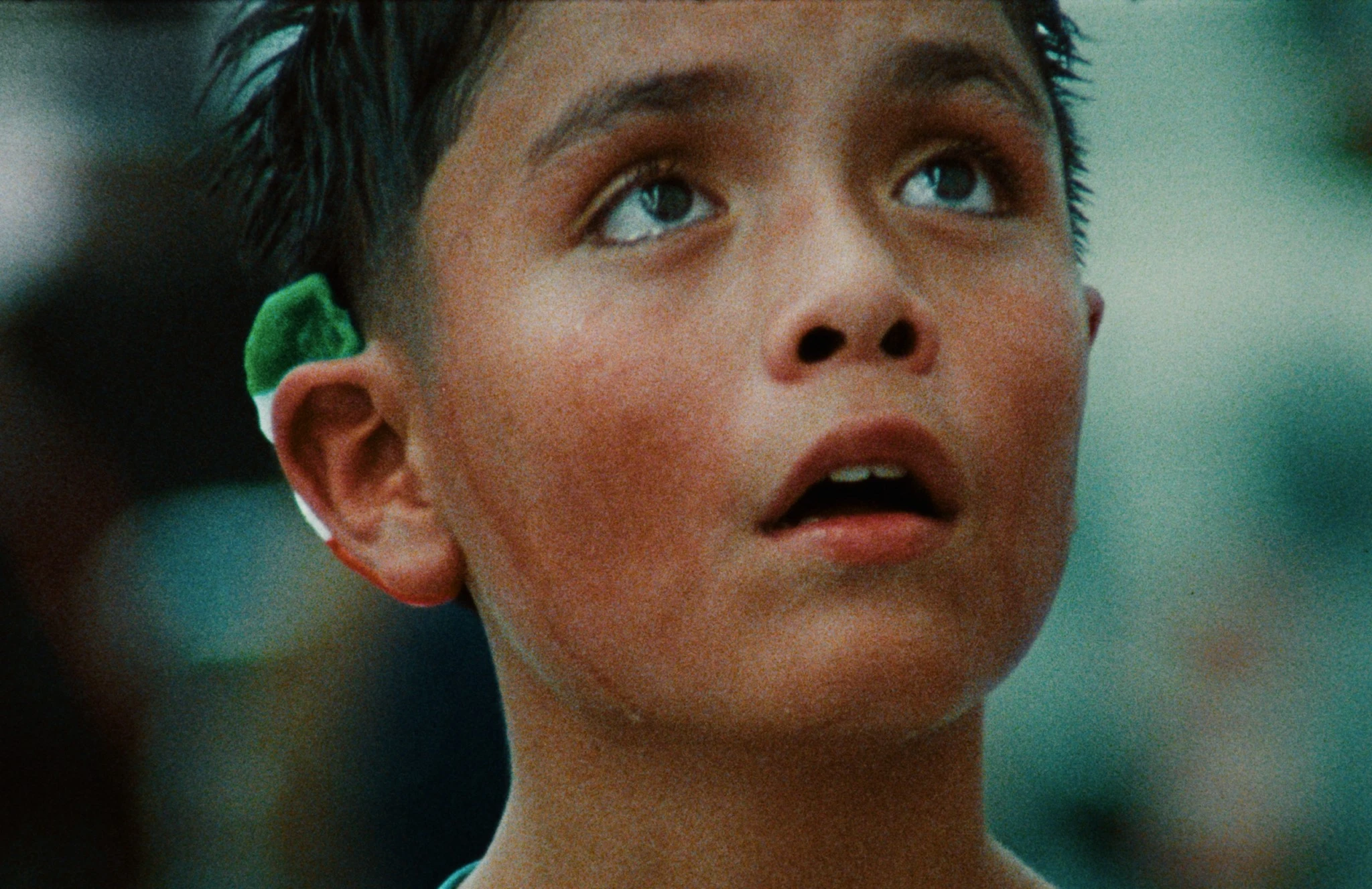 A young boy's face, looking upwards