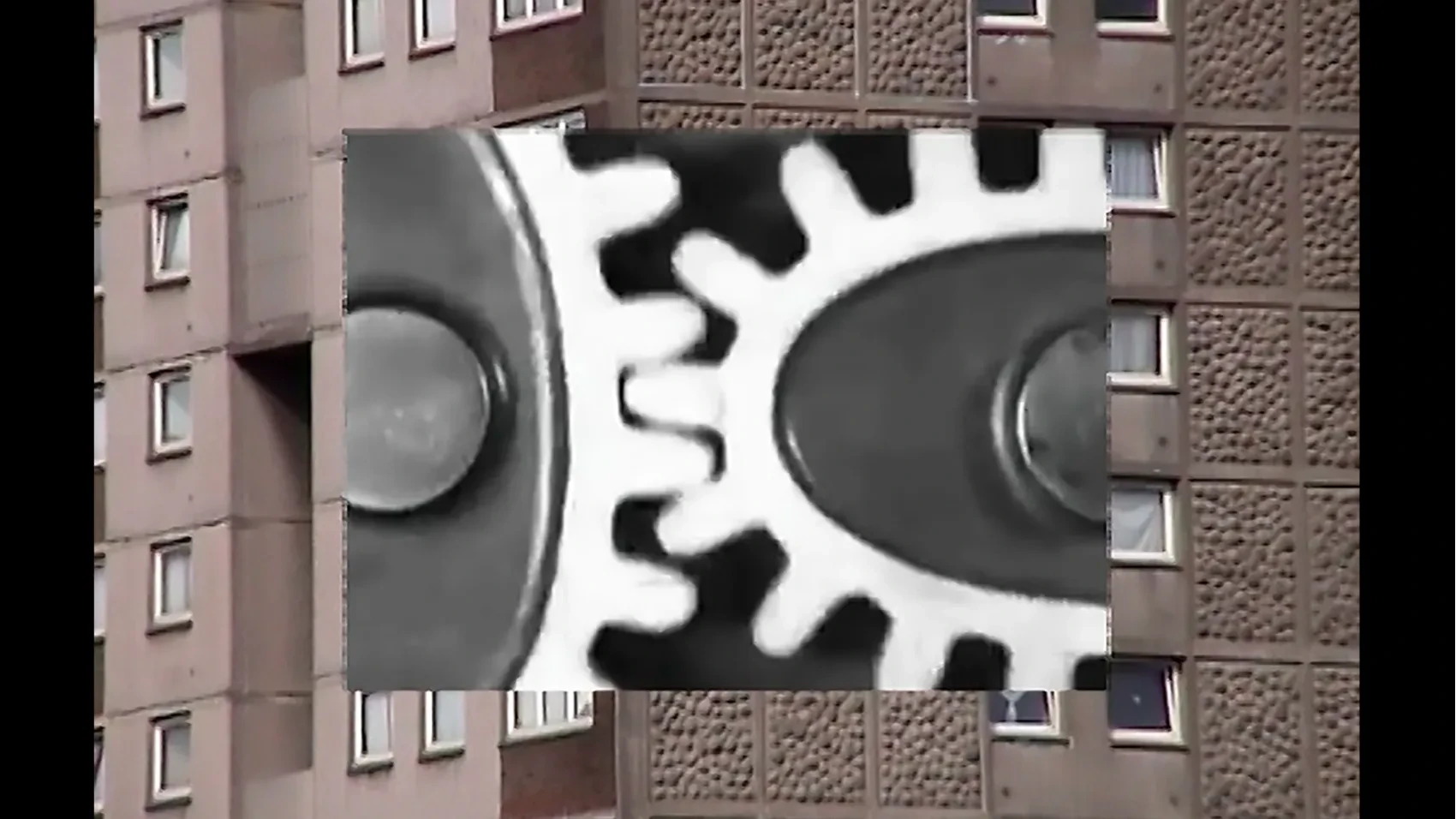 B/W gears against a block of flats