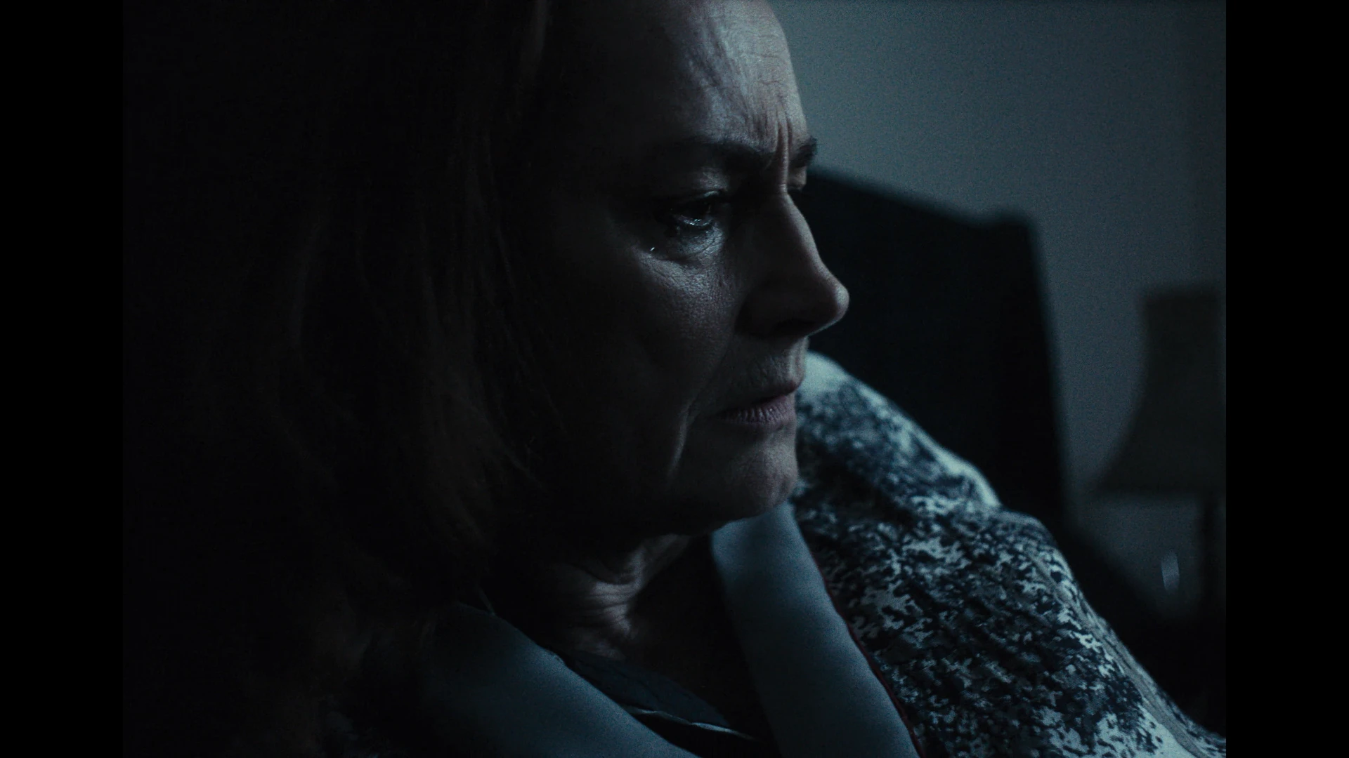 An upset woman looks off out of frame 