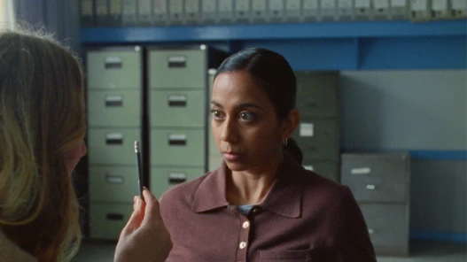 A women focuses on a pencil, which is being held out in front of her by an interviewer