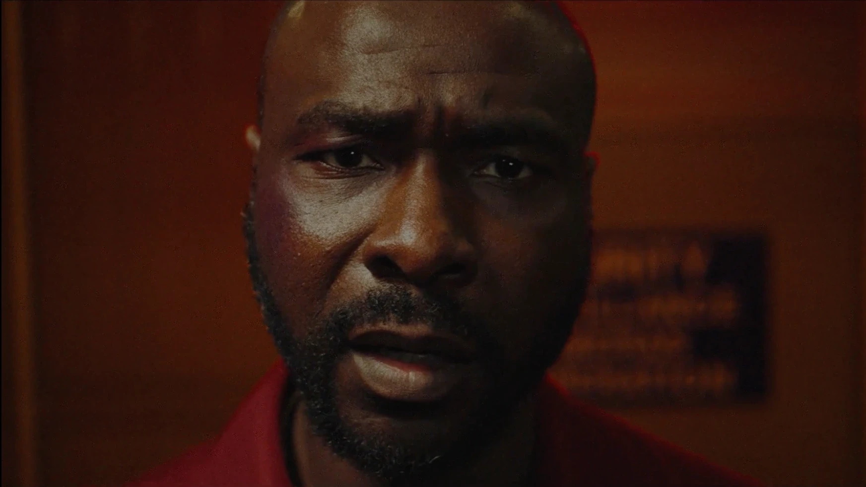 A disturbed looking man stares straight into the camera