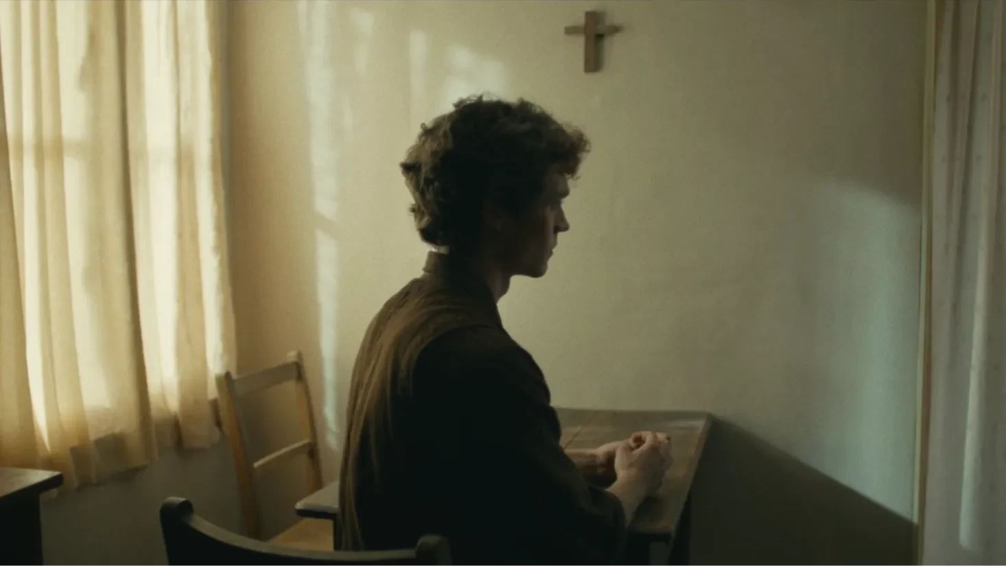Aaron sat pensively beneath a cross.