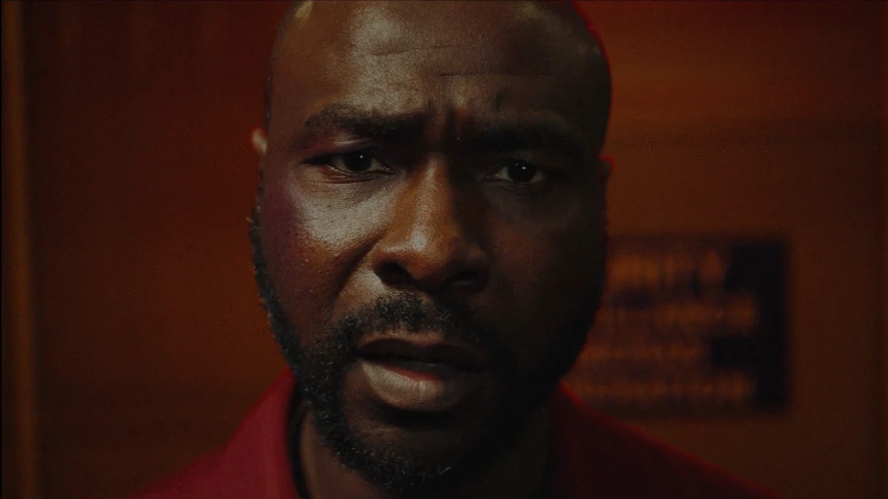 A disturbed looking man stares straight into the camera