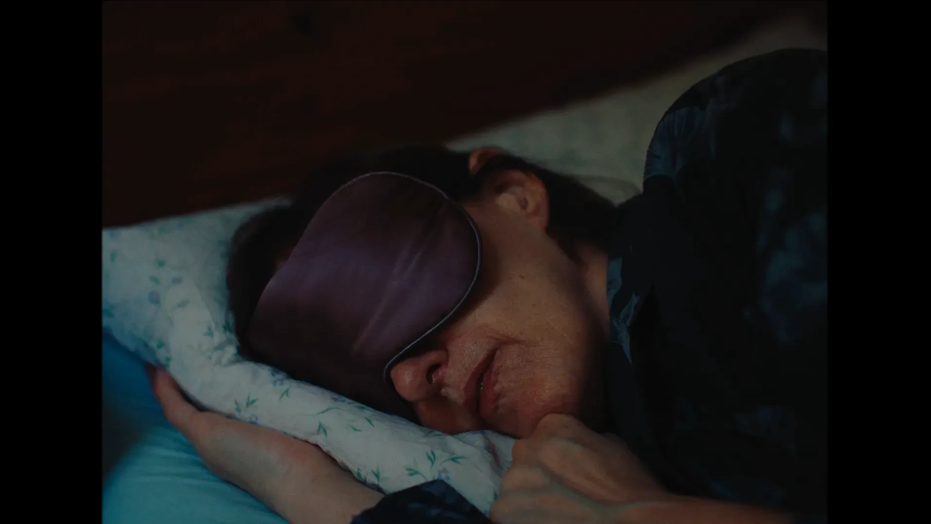 A woman in a sleep mask in bed 